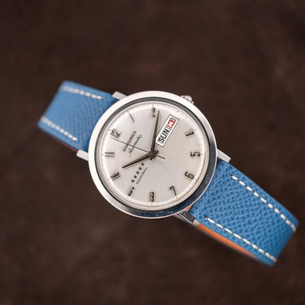 Diagonal overhead of the Longines Admiral automatic, silver sunburst dial and polished bezel showing honest wear from wrist use