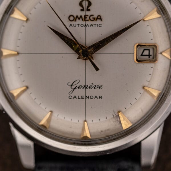 Macro of the Omega Geneve Calendar dial with coppery plating loss across the dauphine hour and minute hands