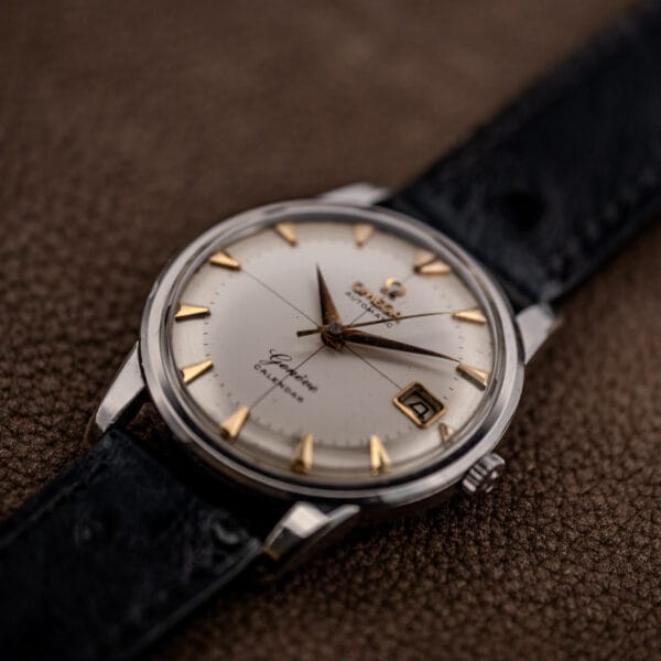 Three quarter view of the Omega Geneve Calendar showing stepped bezel, domed crystal and faceted stainless lugs