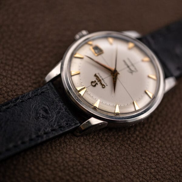 Low angle on the Omega Geneve Calendar case, showing polished bezel edge nicks and downturned faceted lugs