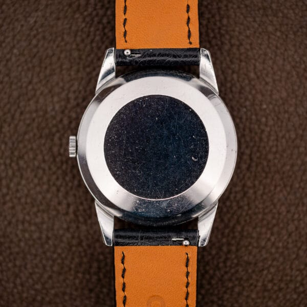 Plain stainless caseback of the Omega 2982-3 SC covered in fine scratches from decades of honest wear