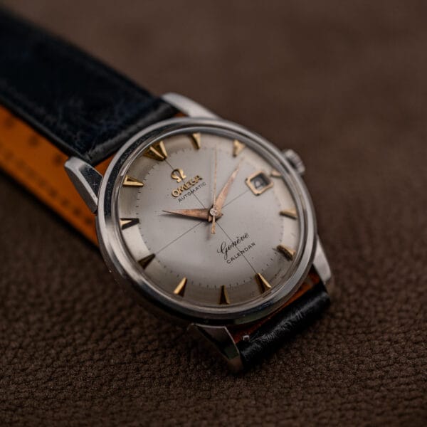 Omega Geneve Calendar viewed from the ten o'clock side with crosshair dial, stepped steel bezel and worn strap