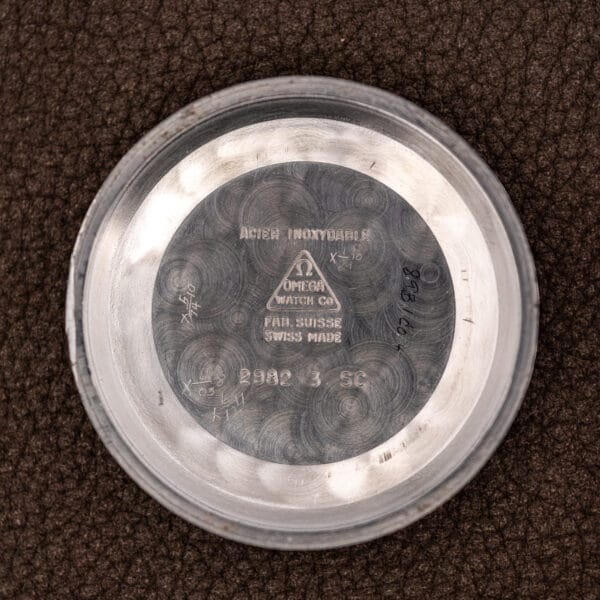 Inner caseback of the Omega Geneve Calendar stamped ACIER INOXYDABLE, FAB. SUISSE and the reference 2982 3 SC