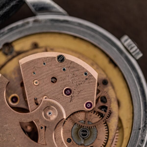 Omega caliber 503 bridge stamped with the Omega symbol and 503, showing gilt finish and jeweled bearings