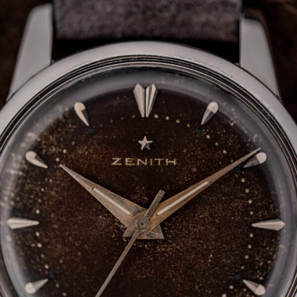 Macro of the Zenith star logo and signature above applied faceted markers on a heavily browned tropical dial