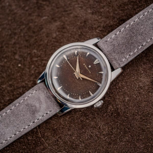 Vintage Zenith angled to show the polished stainless case flank, fluted crown and speckled brown tropic dial