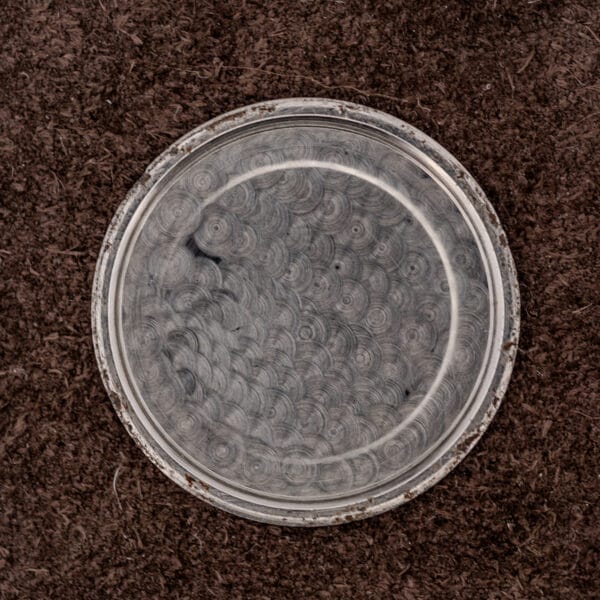 Interior of the removed Zenith caseback showing circular machining marks and light residue on the snap lip