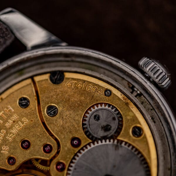 Macro of Zenith movement serial 4741694 stamped in the gilt plate beside the brushed steel ratchet wheel