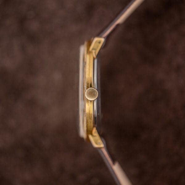Crown-side profile of the Girard-Perregaux case showing the small fluted crown at three and slim downturned lugs