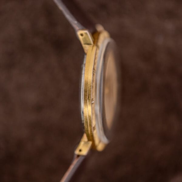 Nine o'clock flank of the Girard-Perregaux case, free of pushers or correctors, with drilled lugs and domed crystal