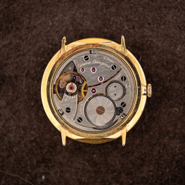 Hand-wound Girard-Perregaux movement with the caseback removed, showing the signed barrel bridge, balance wheel and mainspring barrel