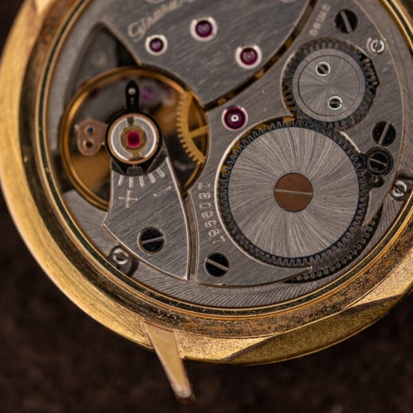 Macro of the Girard-Perregaux balance wheel, shock protection spring, regulator index, ratchet wheel and blued click