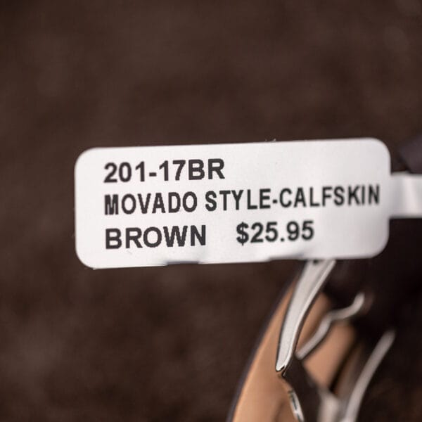 Brown leather replacement strap on the Girard-Perregaux, retail tag attached, with the plain tang buckle below