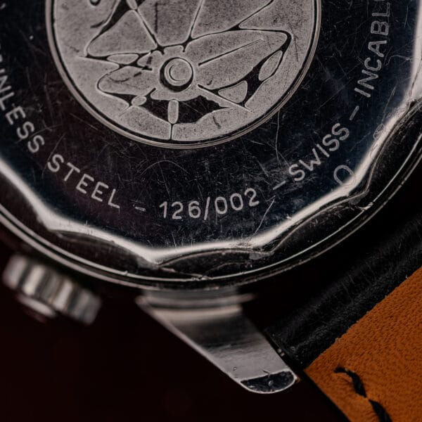 Macro of the reference 126/002 caseback engraving beside the raised Seapearl medallion on this vintage Enicar
