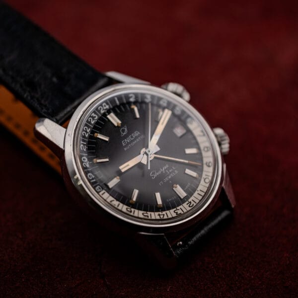 Tan underside of the ostrich pattern strap beside the black dial of an Enicar Sherpa Jet
