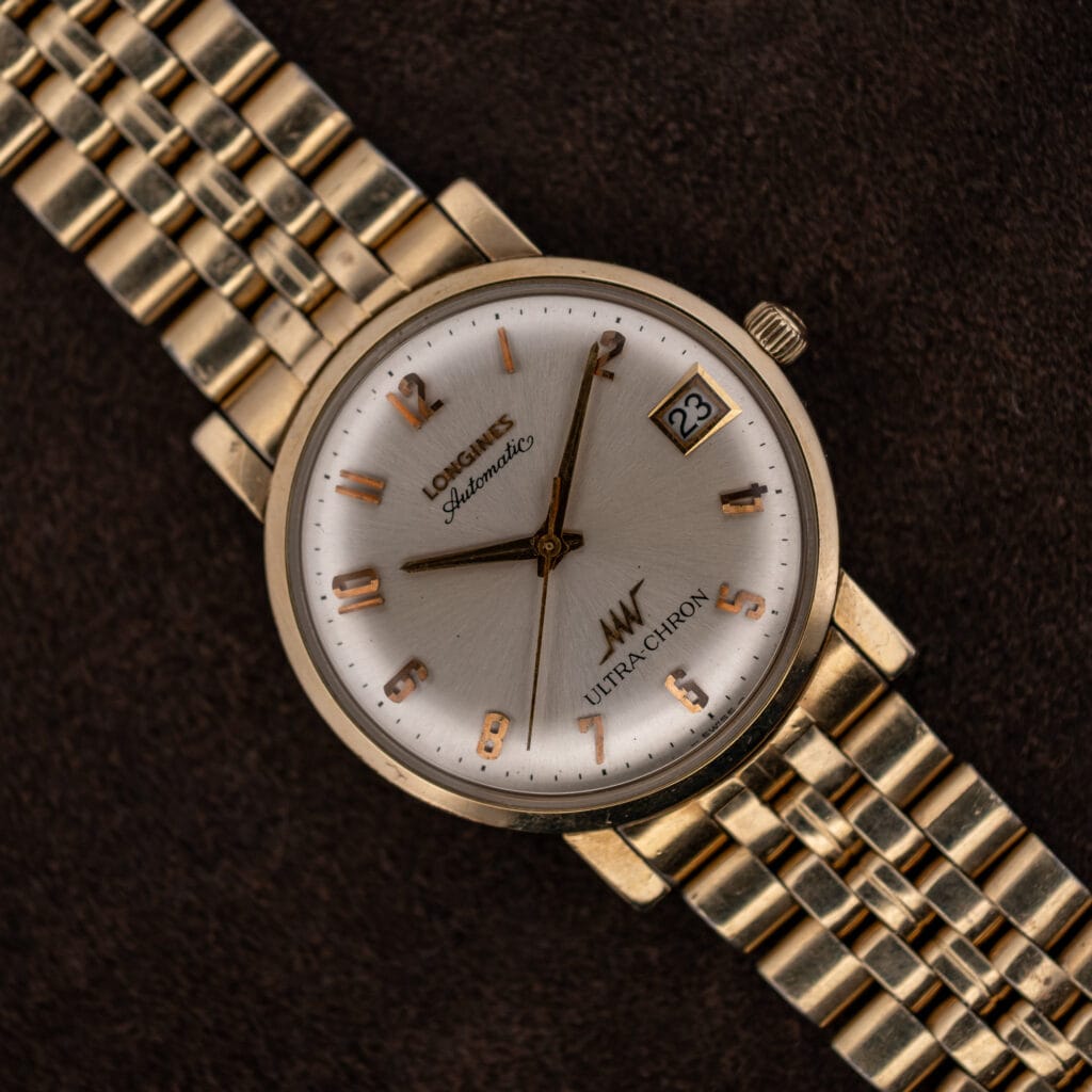Longines Ultra-Chron automatic, silver sunburst dial with applied rose gold numerals and date at three, on gold-tone bracelet