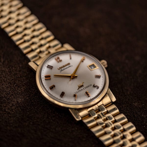 Longines Ultra-Chron photographed from the eight o'clock side with the gold-tone bracelet running diagonally across the frame