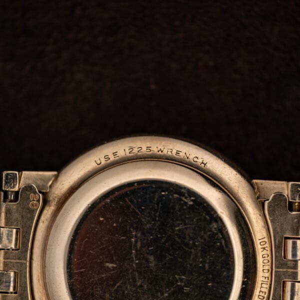 Macro of the 10K GOLD FILLED caseback engraving on the Longines Ultra-Chron beside a bracelet end piece