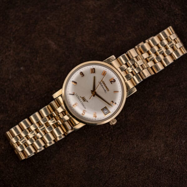 Longines Ultra-Chron automatic laid diagonally on dark brown suede, dial and date window facing the camera