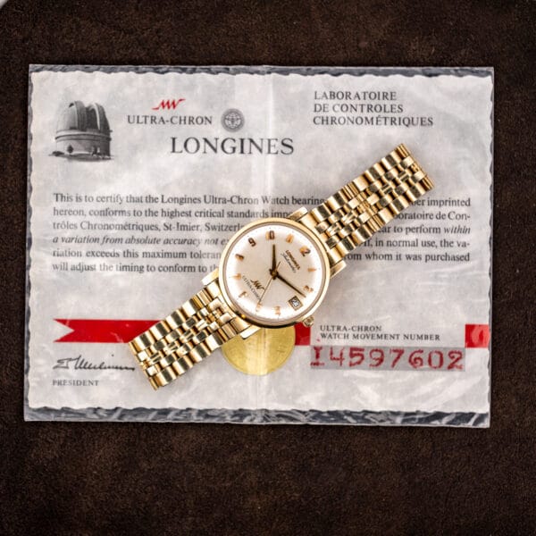 Longines Ultra-Chron resting on its original timing certificate, movement number 14597602 printed in red on the paper