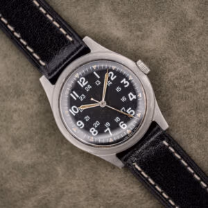 Benrus GG-W-113 sterile black dial with 12-hour and 24-hour numerals, aged tan lume and black leather strap