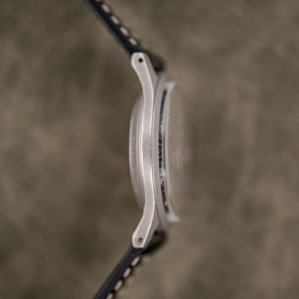 Nine o'clock side of the Benrus GG-W-113 steel case, drilled lugs and low domed crystal with case band wear