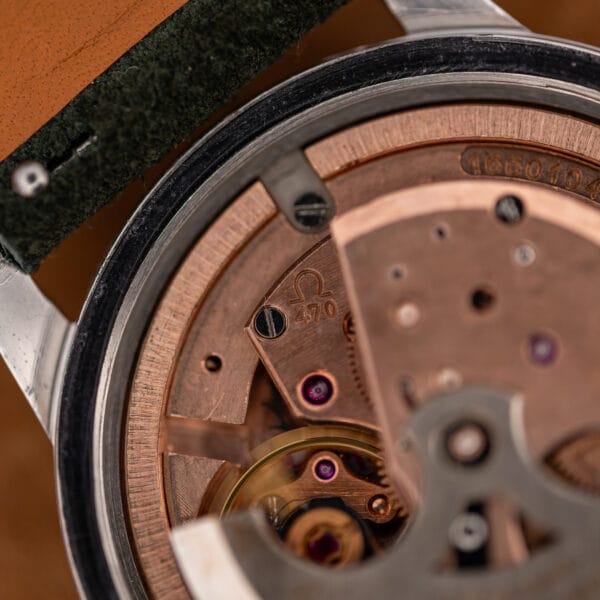 Macro of Omega caliber 470 showing the 470 bridge stamp, rose gold plating and purple jewel bearings