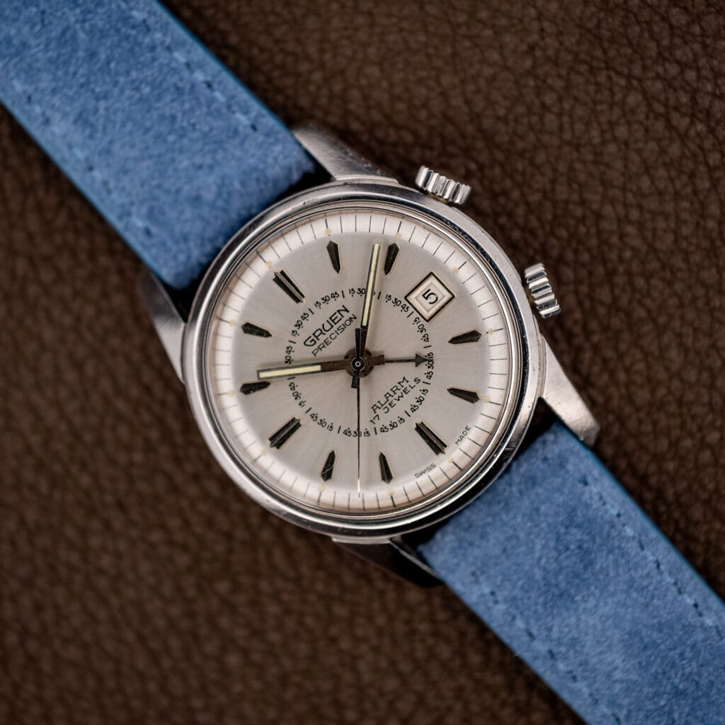 Vintage Gruen Precision Alarm on powder blue suede strap, silver sunburst dial with twin crowns at right