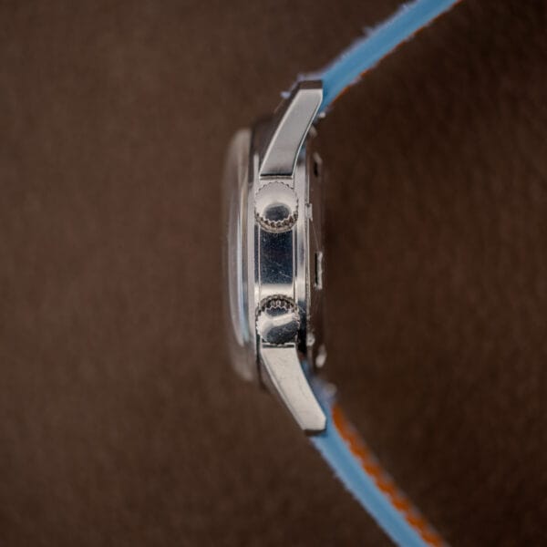 Side profile of the Gruen Precision Alarm showing both crowns, domed acrylic crystal and polished steel flank