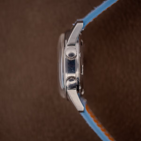 Side profile of the Gruen Precision Alarm showing both crowns, domed acrylic crystal and polished steel flank