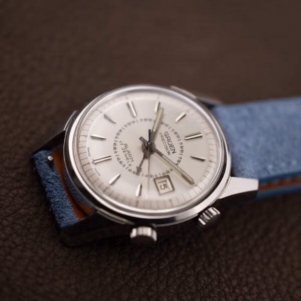 Gruen Precision Alarm angled on blue strap, thin central seconds hand and date window visible