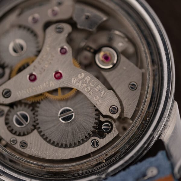 Macro of the Gruen alarm movement stamped GRUEN WATCH Co and UNADJUSTED beside jeweled bearings