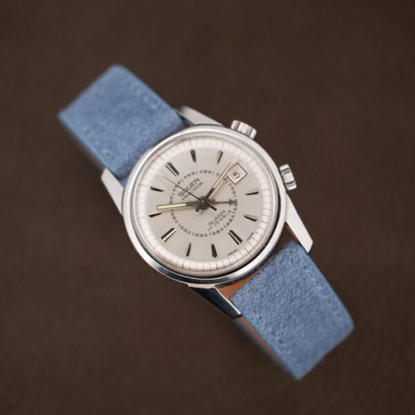 Vintage Gruen alarm watch on powder blue suede, dial printing crisp and hour markers dark and faceted