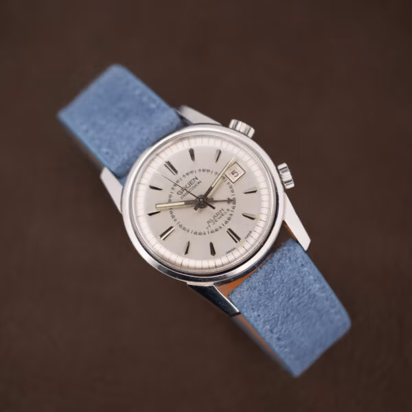 Vintage Gruen alarm watch on powder blue suede, dial printing crisp and hour markers dark and faceted