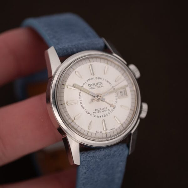 Angled view of the vintage Gruen Precision Alarm, twin crowns, blue suede strap and date window