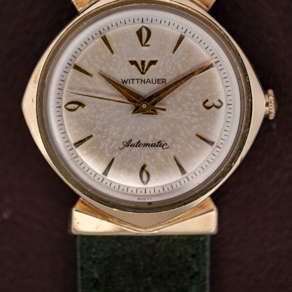 Wittnauer Automatic dial close-up with stylized Arabic numerals, applied gold markers and scattered patina speckling