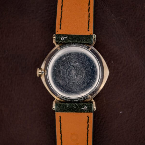 Caseback stamped 10K G.F. BEZEL and STAINLESS STEEL BACK, heavily scratched across the whole surface