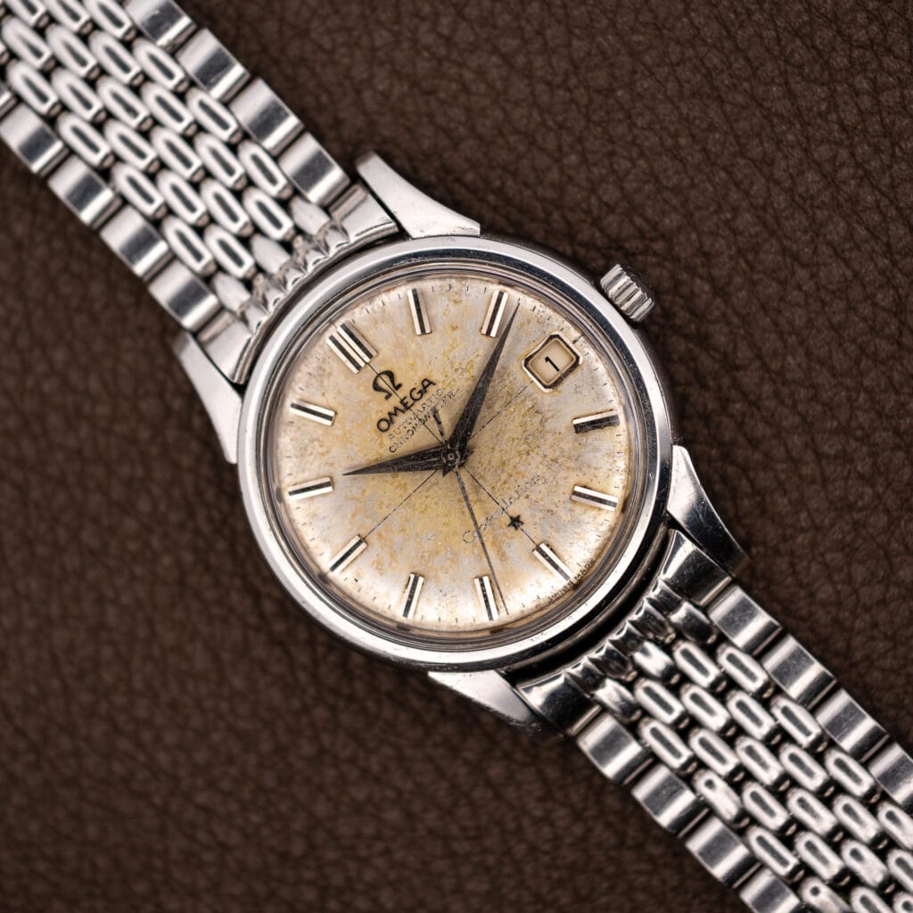 Omega Constellation 14393 with heavily patinated off-white dial and date at three on a steel bracelet