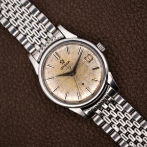 Omega Constellation 14393 with heavily patinated off-white dial and date at three on a steel bracelet