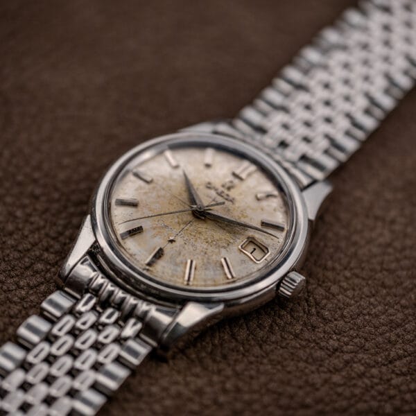 Angled close-up of the Omega 14393 dial mottling, applied Omega logo and faceted date frame at three