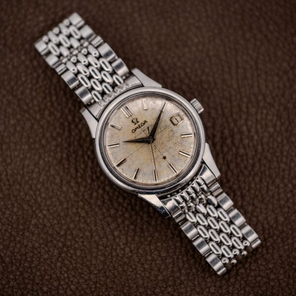 Omega Constellation 14393 front view, tarnished dauphine hands and baton markers across a heavily spotted dial