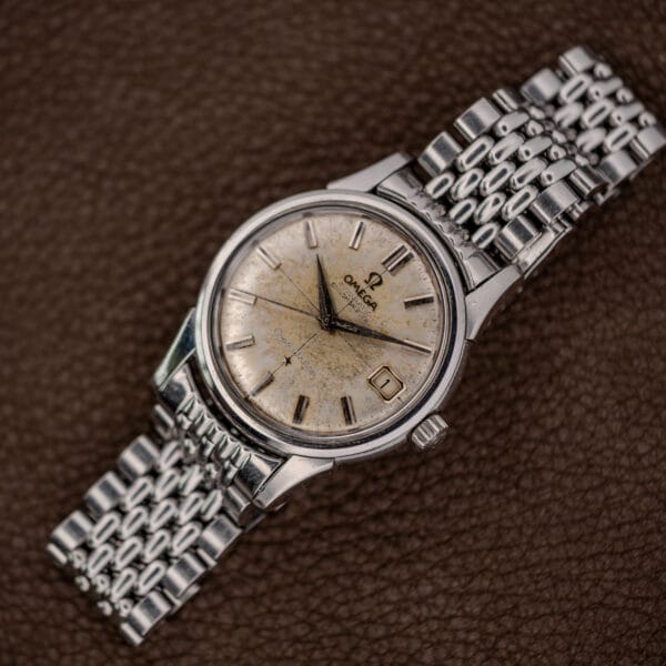 Vintage Omega Constellation 14393 on a steel bracelet, scratched hazy crystal over a deeply aged dial