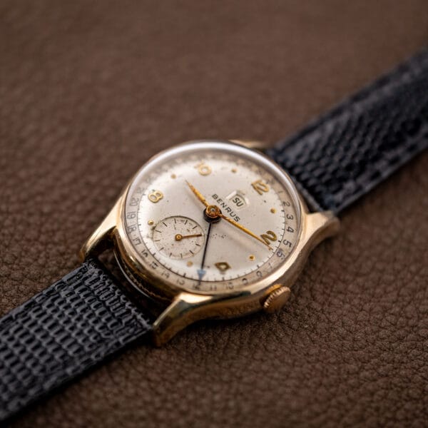 Angled macro of the Benrus calendar dial, small seconds register, applied numerals and oxidised gold-tone hands