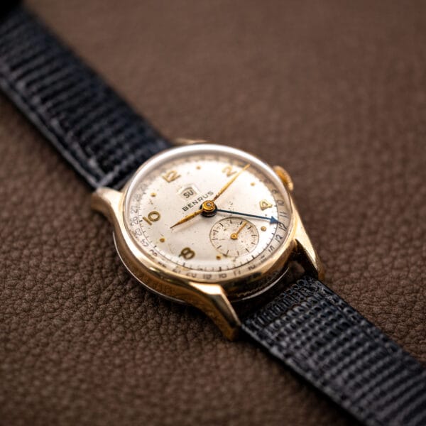 Low three-quarter view of the Benrus pointer date watch, rolled gold plate bezel and black leather strap