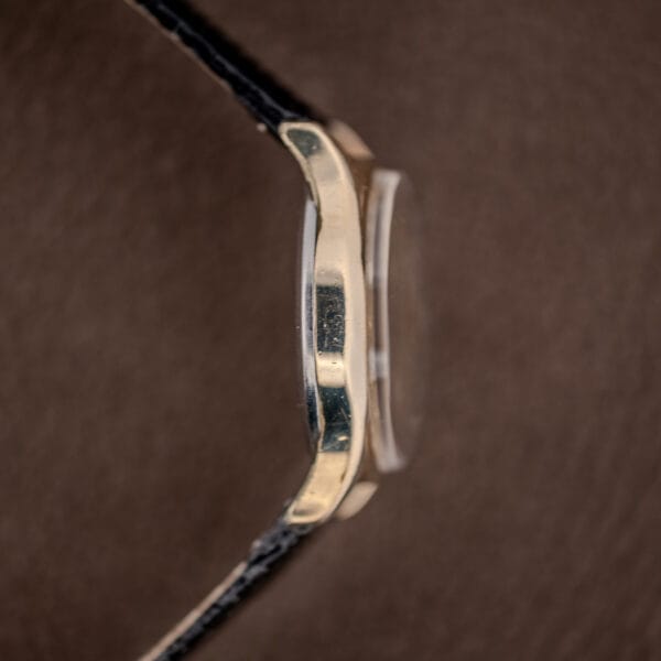 Benrus pointer date case in profile, domed acrylic crystal and black leather strap at the lugs