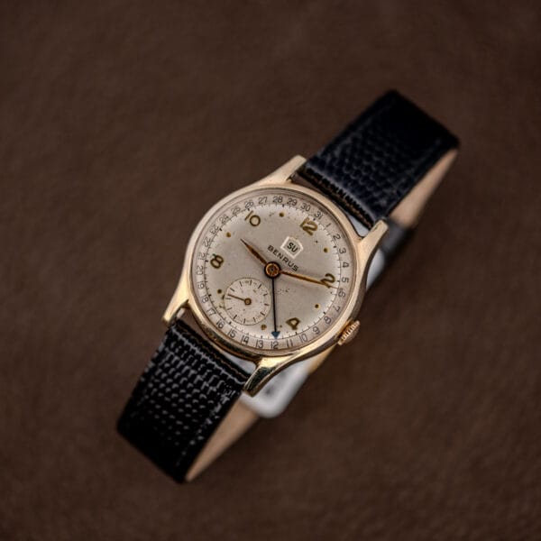 Vintage Benrus pointer date and day watch front view, white dial, gold-tone case and black leather strap