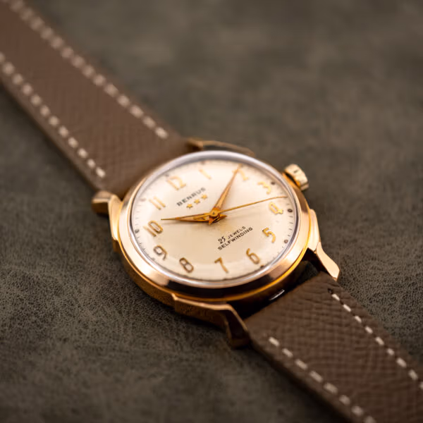 Vintage Benrus automatic angled on taupe Saffiano leather strap, cream dial catching the studio light