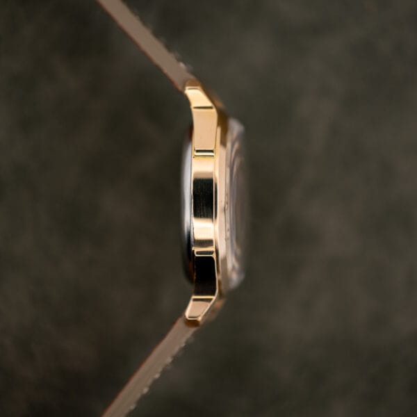 Side view of the Benrus 7155 gold electroplate case, domed crystal edge and taupe leather strap