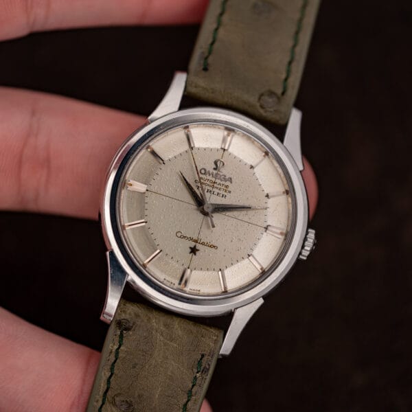 Omega Constellation 14381-7 front view, heavily speckled off-white dial on olive ostrich leather strap