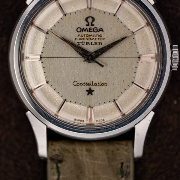 Türler-signed Omega Constellation pie-pan dial close-up with darkened dauphine hands and scratched crystal